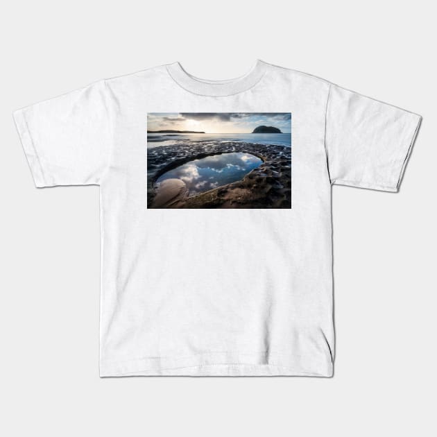 Sky reflections in a rockpool on the nsw central coast near lion island Kids T-Shirt by Geoff79